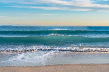 Yeni Zelanda, Tauranga 'daki Maunganui Dağı' nın arka planında dalgalar kırılıyor..