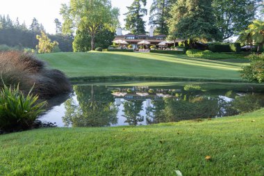 Taupo Yeni Zelanda - 27 Kasım 2021; Sabah ışığı güzel manzaralı topraklarda sakin gölet içindeki konak binalarını yansıtıyor.