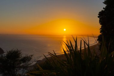 Sunrises over horizon from summit Mount Maunganui