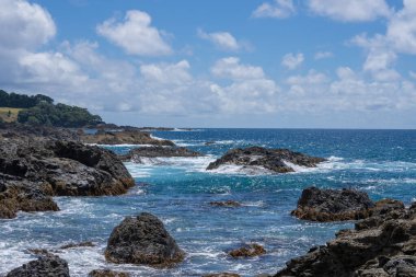 Te Kaha 'daki Bereket Körfezi, Yeni Zelanda' nın doğu kıyısında engebeli kayalık kıyı şeridi ve ufuk manzarası..