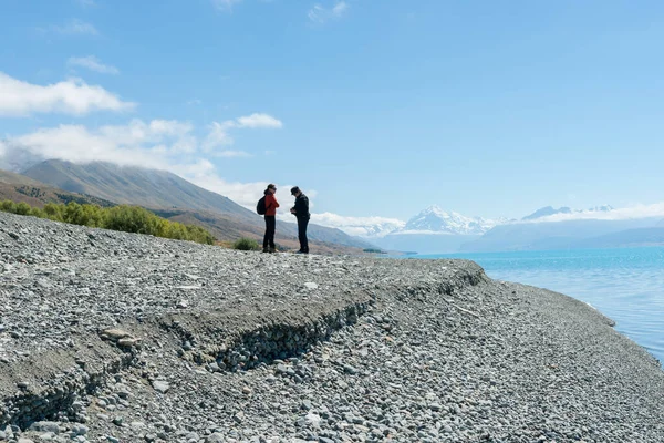 カンタベリーニュージーランド 2015年2月15日 観光客は 南島のカンタベリーにあるプカキ湖のターコイズブルーの水の石の海岸線に立って青い空にシルエット — ストック写真