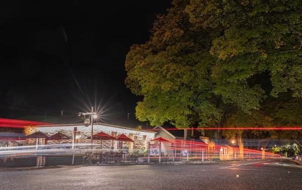 Arrowtown Yeni Zelanda - 21 Nisan 2022; Buckingham Caddesi 'nin köşesindeki bar ve geceleri büyük ağaç.
