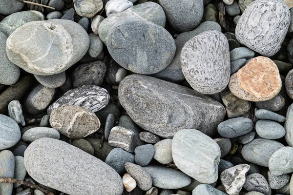 River stones in typical random pattern and type in New Zealand.