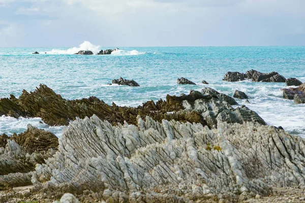 Waves Crash Distant Rocks Cloudy Dull Day Jagged Shoreline Rock — Stock fotografie