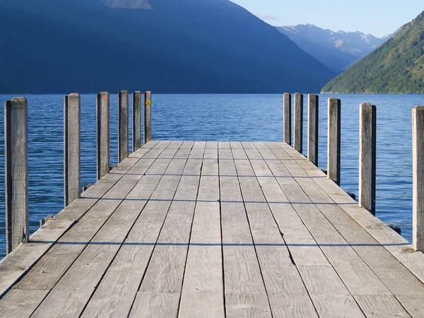 Jetty on Lake Roto-iti projecting into lake with mountain background, Tasman Lakes District, New Zealand.