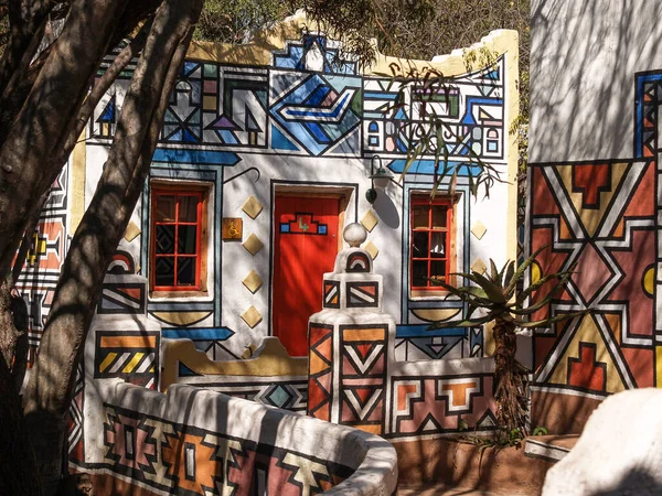 Johannesburg South Africa - August 13 2027; African colours and patterns among shadows from tree branches on exterior of building in a tourist village.