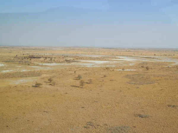 Aerial views of expansive flat landscape while flying over Botswana