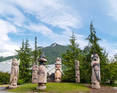 Ketchikan Alaska USA - July 24 2008; Circle of six American Indian totem poles against mountain background