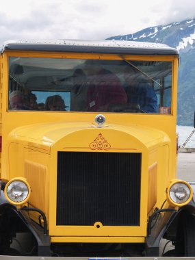Skagway Alaska USA - July 31 2008: Front of bright yellow vintage style vehicle with intricate red motif closeup