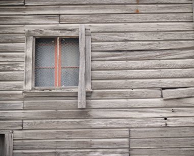 Old unpainted weatherboard wall with window