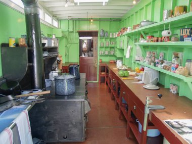 Whitehorse Yukon Territory - August 3 2008; Historic ships galley with cooking equipment on one side and bench, shelves and provision on other,