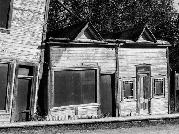 ユーコン準州ドーソンシティの永久凍土の地面の解凍と沈下として崩壊した古い木造建築物 — ストック写真