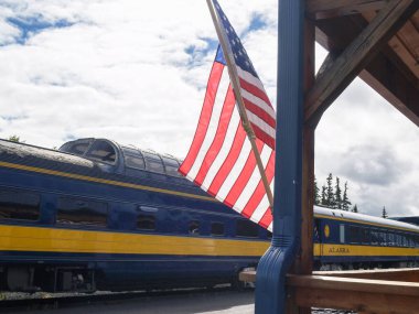 Denali Alaska USA - 10 Ağustos 2008; Tren istasyonu ve tren peronundaki turist treni ve yıldızlar ve çizgili bayrak