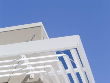 Beyaz çelik dekoratif lombozlar konut binasının yanında.