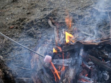 Geleneksel eğlence açık ateşte marşmelov kızartmak..