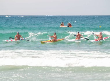 Tauranga Yeni Zelanda - 25 Ocak 2009; Kıyıdaki son dalgada Paddlers hayat kurtaran bir yarışma