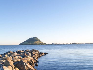 Limandan Yeni Zelanda 'daki Maunganui Dağı' na kadar uzanan kaya dalgaları.