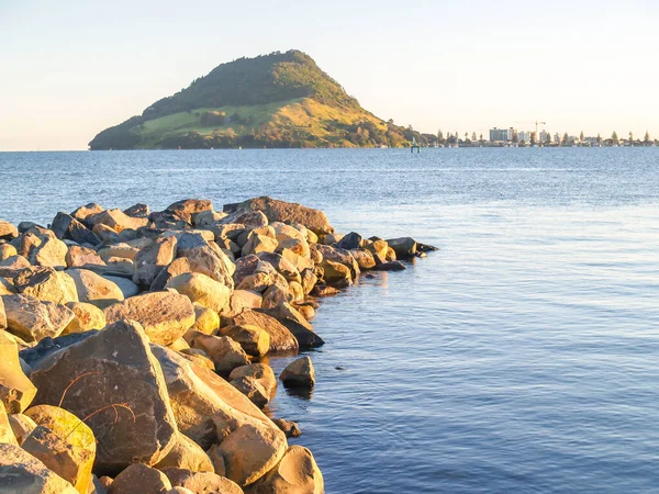 Limandan Yeni Zelanda 'daki Maunganui Dağı' na kadar uzanan kaya dalgaları.