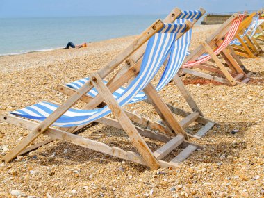 Brighton Plajı ve karakteristik çizgili plaj sandalyeleri mavi ya da kırmızı ve beyaz.