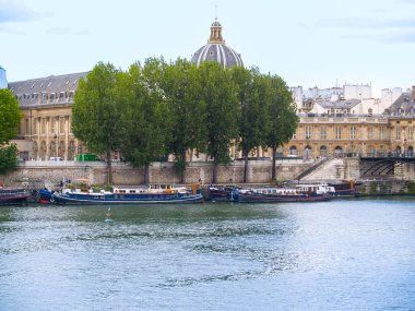 Nehir tekneleri Seine Nehri boyunca demirledi. Şehir silüeti ve kubbe arkasında, Paris, Fransa..