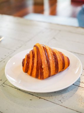 Çikolatalı kruvasan ahşap masaya yakın.