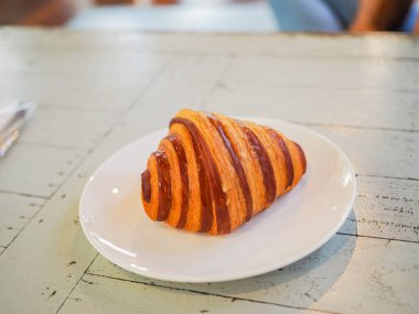 Çikolatalı kruvasan ahşap masaya yakın.