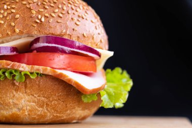 Köfteli burger, domatesli soğan, siyah arka planda fotokopi alanı.