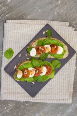 Siyah tahtada fesleğen domatesli sandviç.