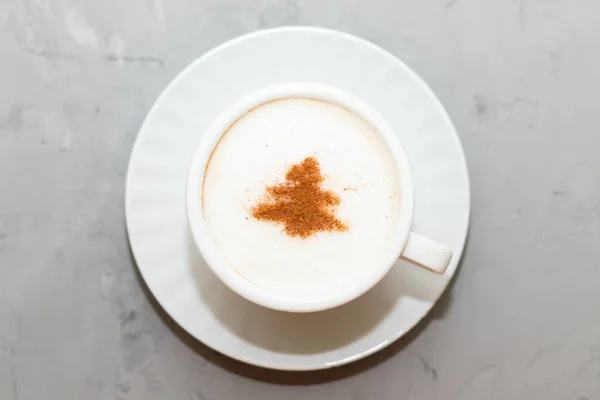 Filiżanka kawy cappuccino z cynamonem, napój świąteczny, na betonowym tle — Zdjęcie stockowe