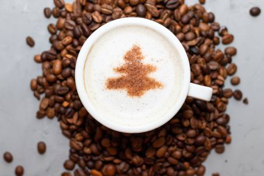 Bir fincan kahve kapuçino. Beton bir arka planda ringa kemiği ve fotokopi alanı var.