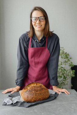 Mayasız ekşi ekmek. Avrupalı güzel bir fırıncı elinde ekmek tutuyor.