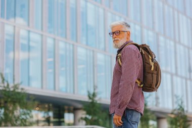 Gömlekli ve dizüstü bilgisayarlı kıdemli bir işadamı büyük bir şirkette kariyer yapıyor.