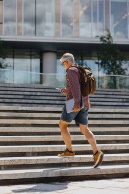 Gömlekli ve dizüstü bilgisayarlı kıdemli bir işadamı büyük bir şirkette kariyer yapıyor.