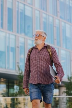 Gömlekli ve dizüstü bilgisayarlı kıdemli bir işadamı büyük bir şirkette kariyer yapıyor.
