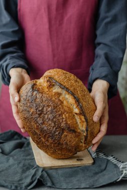 Mayasız ekşi ekmek. Avrupalı güzel bir fırıncı elinde ekmek tutuyor.