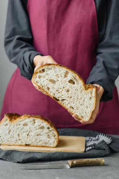 yeast-free sourdough bread. a beautiful European woman baker holds bread in her hands