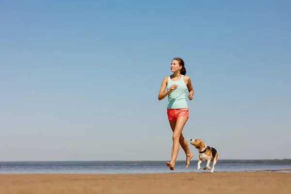 美しいと運動ヨーロッパの女の子は彼女の犬と自然の中でスポーツをします。新鮮な空気の中でのフィットネスとヨガ. ストック画像