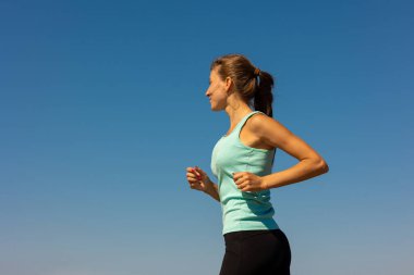 Güzel ve atletik Avrupalı bir kız köpeğiyle doğada spor yapıyor. Zindelik ve yoga temiz havada. 