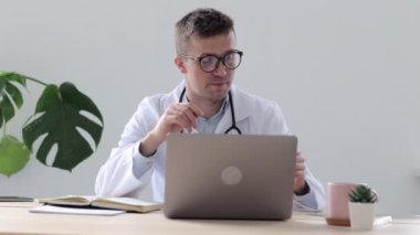 Klinikte Avrupalı bir doktor bir hastayla video bağlantısı üzerinden konuşuyor, hastanede bir beyaz doktor bir hastaya web kamerasıyla teşhis koyuyor.
