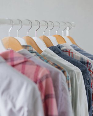 Soyunma odasında ya da askıda giysiler, gömlekler ve elbiseler. Bir giyim mağazası ya da butik. Bir kadın kuaför bir gardırop aldı.