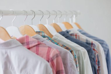 Soyunma odasında ya da askıda giysiler, gömlekler ve elbiseler. Bir giyim mağazası ya da butik. Bir kadın kuaför bir gardırop aldı.
