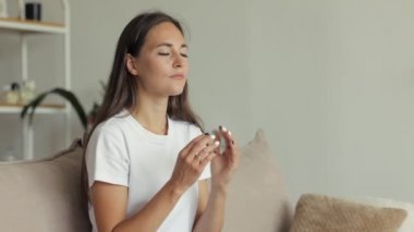 Avrupalı bir kadın evinde kanepede meditasyon yapıyor. Küçük bir çocuğun annesi manevi uygulamalara ve yogaya bağlıdır.