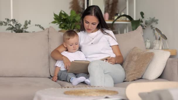Europejska rodzina mama i syn bawią się i czytają książkę w domu. samotna matka wychowuje dziecko — Wideo stockowe