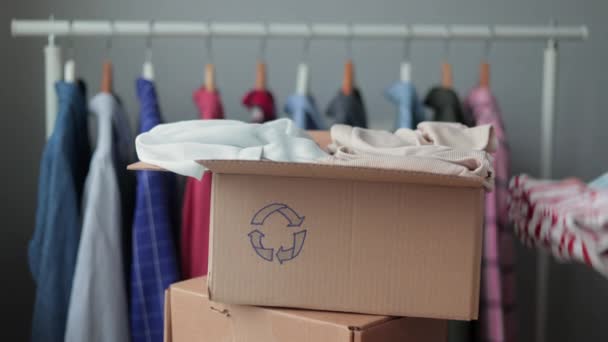 A woman collects clothes in a box for recycling or disposal.european woman sorting plastic and garbage eco friendly lifestyle — Stock Video