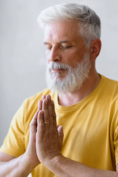 白髪の男が瞑想して呼吸法をしてる。高齢者のためのスポーツフィットネスや体操 — ストック写真