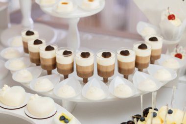 Plastik bardaklarda güzel tatlılar, güzel dekore edilmiş şekerler, ziyafet için tatlılar.