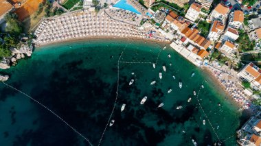 Karadağ 'daki tekne rıhtımı ve yat limanının havadan aşağı görüntüsü. Beyaz özel motorlu tekneler Adriyatik deniz kıyısındaki iskeleye demirlemiş. Yat tekneleri park ediyor. Fotoğraf: İHA.