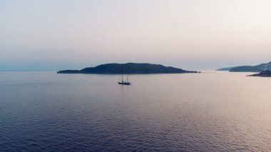 Manzaralı gün batımında Akdeniz 'de yelkenli gezisi. Lüks bir yat ve deniz seyahati. Yelkenlinin hava görüntüsü 
