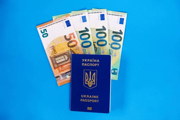 Ukrayna Vatandaşlarının Iki Biyometrik Pasaportu Mavi Arka Planda Avro Banknotları — Stok fotoğraf