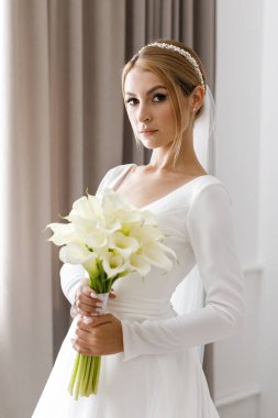 Gelin elinde bir buket tutuyordu. Zarif beyaz düğün buketi. Gelin elinde bir buket zambak tutuyor.
